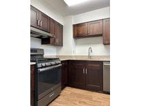 Well-lit kitchen with stainless steel appliances, granite countertops, and brown cabinetry at 2479 Peachtree Ne Rd # 317, Atlanta, GA 30305