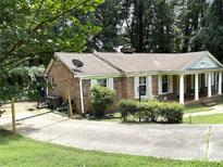 Charming brick home with white columns and shutters, nestled on a lot with mature trees at 3006 East Point Street, East Point, GA 30344
