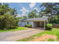 Charming single-story home with a covered carport, lush landscaping and well-manicured lawn at 502 Snowfall Ter, Palmetto, GA 30268