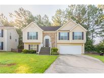 Charming two-story home with a manicured lawn, brick accents, and attached two-car garage at 5033 Kens Ct, Stockbridge, GA 30281