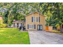 Inviting two-story home with a well-maintained lawn, black shutters, a chimney, and a cozy front entrance at 5383 Forest East Ln, Stone Mountain, GA 30088