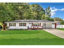 Charming single-story home featuring a well-manicured lawn, a covered porch, and a long driveway at 288 Valerie Cir, Hiram, GA 30141