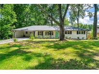 Charming single-story home with a lush green lawn and mature trees surrounding the property at 4103 Laynewood Cir, Tucker, GA 30084