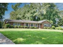 Charming brick home with a well-manicured lawn, lush greenery, and inviting curb appeal at 4581 Newcastle Cir, Lithonia, GA 30038