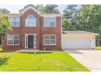 Charming brick two-story home with a well-manicured lawn and attached two-car garage at 5867 Heritage Walk, Lithonia, GA 30058