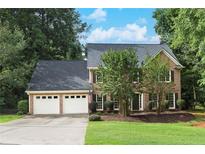 Traditional brick home featuring a two-car garage and a well-manicured front yard, offering classic charm at 2031 Greyfield Nw Dr, Kennesaw, GA 30152