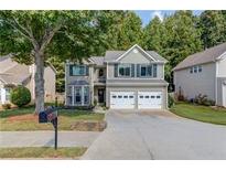 Charming home showcasing a well-maintained lawn, mature tree, and a convenient two-car garage at 3485 Parkbrooke Ln, Duluth, GA 30096