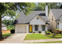 Charming single-Gathering home with a yellow door, a well-manicured lawn, and an attached one-car garage at 1334 Gates Se Dr, Atlanta, GA 30316