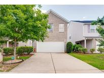 Charming two-story brick home featuring an attached two-car garage and mature landscaping at 1574 Leonard St, Hampton, GA 30228