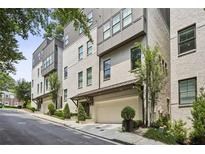 Modern townhome exterior with painted brick, attached garages, and manicured landscaping at 1821 Huntington Hills Nw Ln, Atlanta, GA 30309