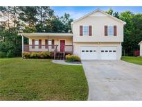 Charming two-story home with vinyl siding, a front porch, attached two-car garage, and a well-manicured front lawn at 421 River Trace Dr, Villa Rica, GA 30180
