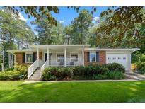 Charming brick home with a covered porch and lush landscaping providing great curb appeal at 1959 Audubon Ne Dr, Atlanta, GA 30329