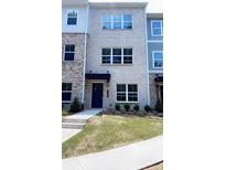 Charming brick townhome with multiple windows and well-manicured lawn at 5447 Blossomwood Sw Trl, Mableton, GA 30126