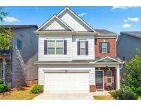 Charming two-story home with a well-maintained lawn, attached garage and inviting curb appeal on a sunny day at 2859 Woodward Down Trl, Buford, GA 30519
