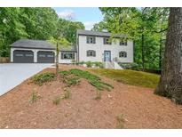 Charming two-story home featuring a two-car garage, blue front door and well-maintained landscaping at 9805 Buice Rd, Alpharetta, GA 30022