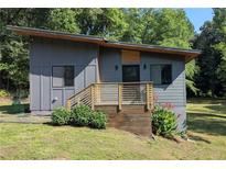Striking modern home featuring sleek gray siding, wooden accents, and a beautifully landscaped entrance at 1092 Hillcrest Se Dr, Atlanta, GA 30316