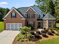 Charming two-story brick home with a manicured lawn and a two-car garage at 7198 Golfside Se Dr, Covington, GA 30014
