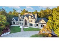 Stunning two-story home with a manicured lawn, elegant architectural details, and a circular driveway at 1806 Wynthrop Manor Sw Dr, Marietta, GA 30064