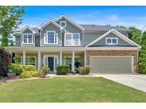 Charming two-story home featuring a well-manicured lawn, inviting porch, and a two-car garage at 204 Sawtooth Ct, Canton, GA 30114