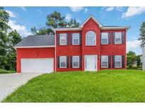 Charming two-story red brick home with a well-manicured lawn and a two-car garage at 1029 Chaterly Ct, Riverdale, GA 30296