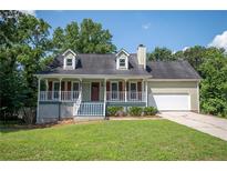 Charming home featuring a quaint front porch, well-maintained lawn, and attached two-car garage at 3381 Birchwood Trl, Snellville, GA 30078