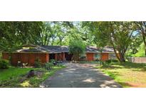Charming single-story home with a long driveway and a wooded front yard at 1717 Briarbend Ct, Stone Mountain, GA 30088