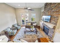 Bright living room with stone fireplace, high ceilings, ceiling fan, and plush seating arrangement at 255 Southerland Ne Ter # 207, Atlanta, GA 30307