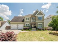 Two-story home featuring an attached three-car garage, stone accents, and well-manicured lawn at 875 Soaring Cir, Marietta, GA 30062