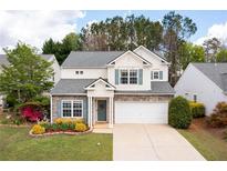 Charming two-story home featuring stone accents, a well-manicured lawn, and an attached two-car garage at 245 Weatherstone Pointe Dr, Woodstock, GA 30188