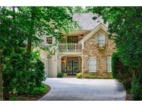 Charming stone and stucco home with inviting balcony and lush landscaping at 1020 Matheson Way, Johns Creek, GA 30022