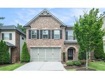 Two-story brick home featuring a two-car garage and well-maintained landscaping at 1878 Weston Ln, Tucker, GA 30084