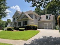 Charming two-story home with a well-manicured lawn and attached two car garage at 5014 Dovecote Trl, Suwanee, GA 30024