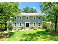 Charming two-story home with a lush green lawn and mature trees at 5018 Old Ivy Rd, Peachtree Corners, GA 30096