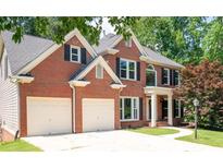 Classic two-story brick home with black shutters and a two-car garage at 672 Red Sunset Cir, Powder Springs, GA 30127