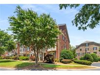 Attractive brick townhome with flowering tree and manicured landscaping at 11271 Calypso Dr, Alpharetta, GA 30009
