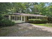Charming single-story home with a mature trees, a driveway, and shuttered windows at 1194 Robert Ln, Marietta, GA 30062
