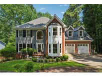 Charming two-story home boasts mature landscaping, grey siding, and a two-car garage at 1518 Maplewood Ct, Woodstock, GA 30189