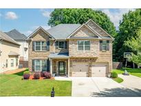 Beautiful two-story brick home featuring a two-car garage and manicured front lawn at 4227 Meadow Wind Dr, Snellville, GA 30039