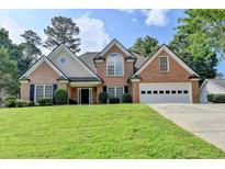 Charming two-story brick home with a well-manicured lawn and attached two-car garage at 430 Tara Oaks Ct, Lawrenceville, GA 30043