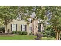 Charming two-story home featuring a stone facade and manicured landscaping at 2455 Stonevalley Ln, Cumming, GA 30041