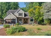 Charming two-story home with a well-manicured front yard and inviting pergola-covered entrance at 1270 Taylor Oaks Dr, Roswell, GA 30076