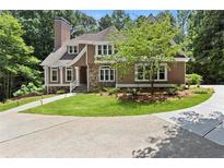 Charming home featuring manicured lawn, stone accents, brown stucco, and elegant white trimmed windows at 5455 Malone Ct, Powder Springs, GA 30127