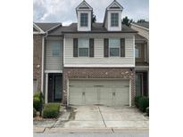 Charming two-story townhouse featuring a two-car garage and dormer windows at 5671 Radford Loop, Fairburn, GA 30213