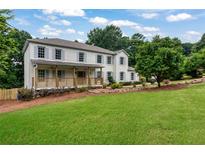 Charming two-story home with white painted brick, front porch, manicured lawn, and gray shutters at 2015 Clipper Straits, Snellville, GA 30078