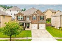 Charming two-story brick home with a well-manicured lawn and two-car garage, perfect for a growing Gathering at 3869 Maiden Fern Ln, Snellville, GA 30039