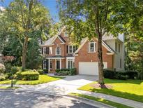 Charming brick home with a manicured lawn, lush landscaping, and a two-car garage at 1575 Wynridge Pointe, Alpharetta, GA 30005