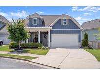 Charming blue two-story home featuring a welcoming front porch and a two-car garage at 876 Samples Nw Ln, Atlanta, GA 30318