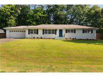 Charming single-story home with a well-manicured lawn, white brick facade, and blue shutters at 159 Lloyd Dr, Marietta, GA 30066