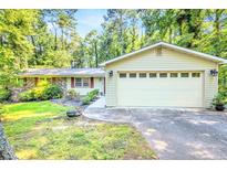 Charming home with a two-car garage and well-maintained landscaping, nestled among mature trees at 1445 Woodhill Dr, Marietta, GA 30066