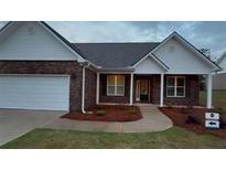 Charming brick home featuring a two-car garage and inviting front porch at 210 Park Place Trl, Social Circle, GA 30025